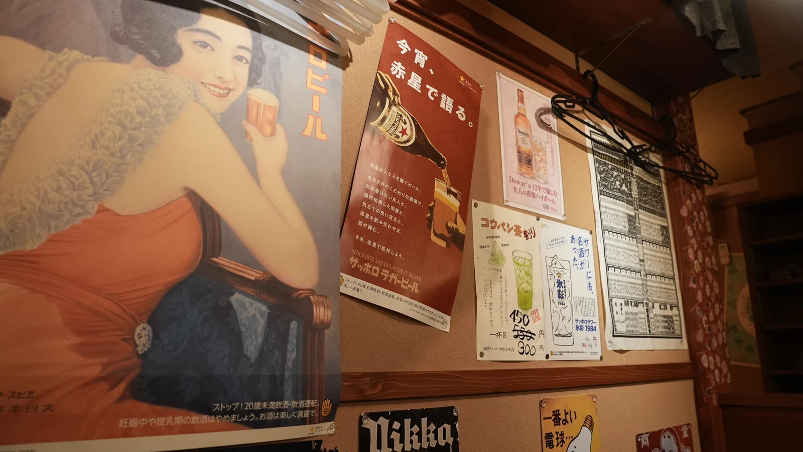 金木犀の壁に飾られた昭和を感じるレトロな広告ポスター